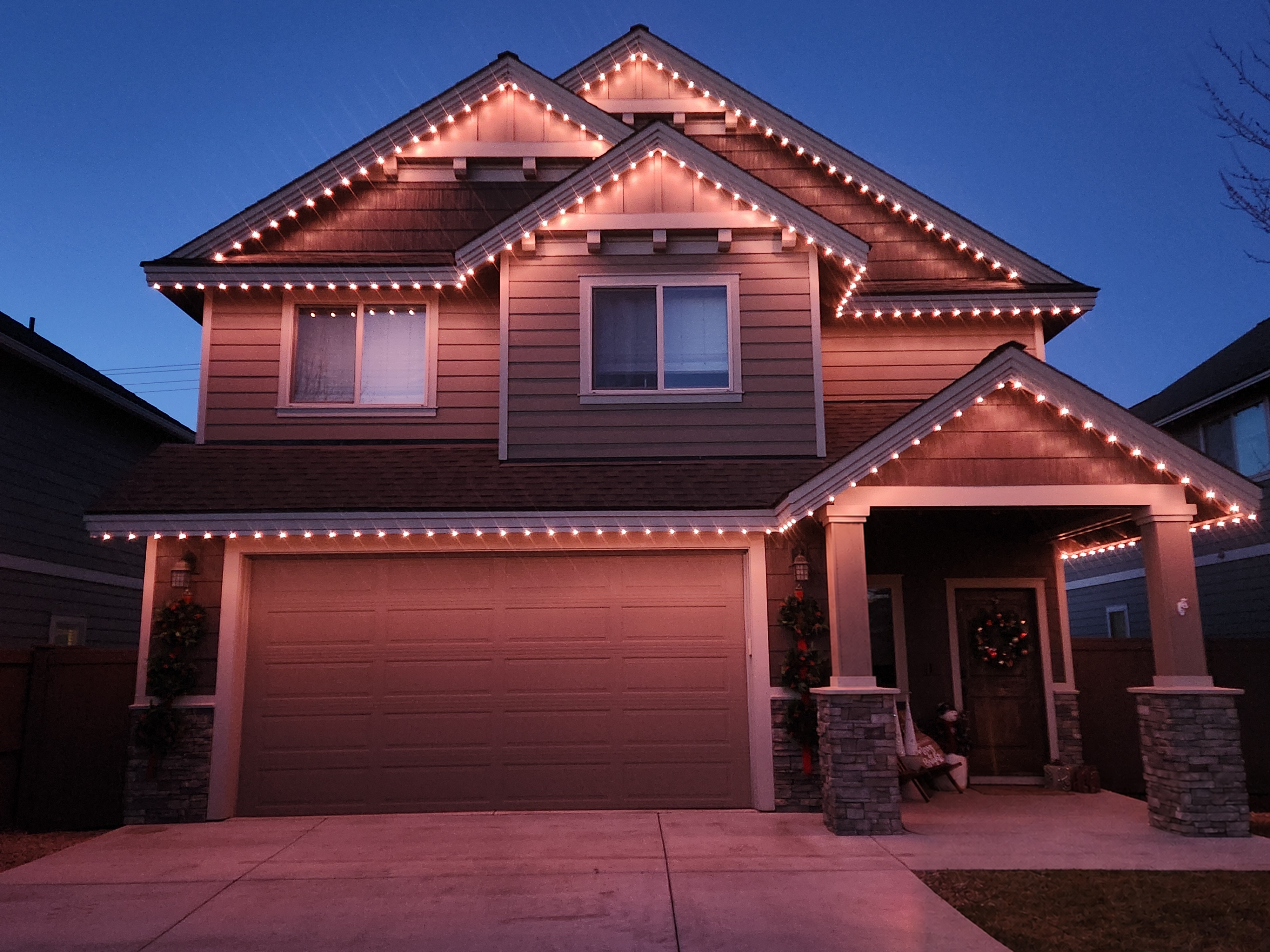 Permanent warm white roofline lighting on a two-story home